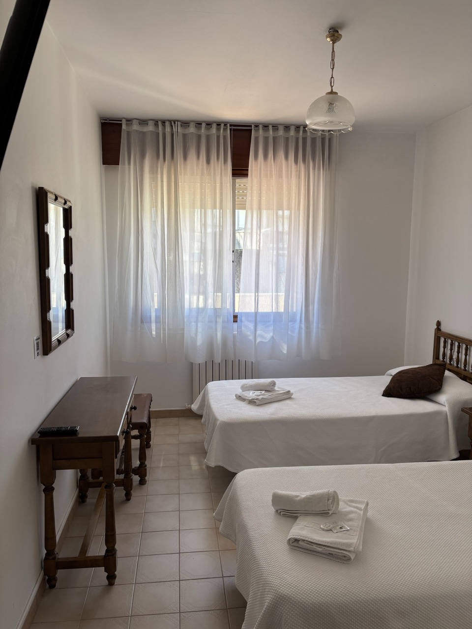 Dormitorio con dos camas individuales y ventana luminosa en Vilagarcia